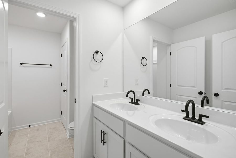 A bathroom with white cabinets.