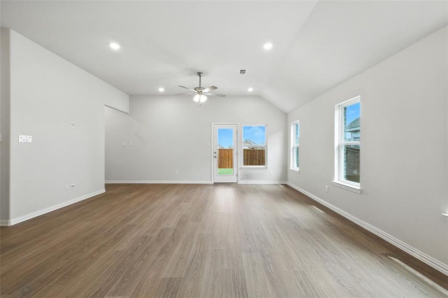 Unfurnished living room featuring light wood-style floors, recessed lighting, lofted ceiling, and a ceiling fan Unfurnished living room featuring light wood-style floors, recessed lighting, lofted ceiling, and a ceiling fan