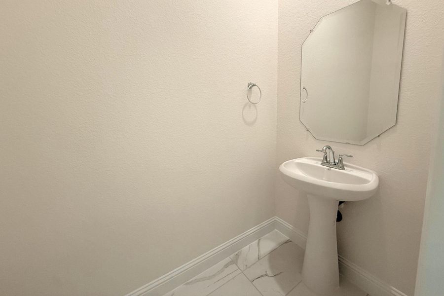 Bathroom featuring marble look tiles and baseboards