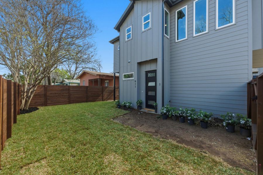 Back of property featuring board and batten siding and a fenced backyard