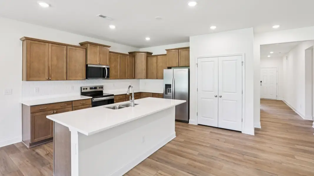 Pendleton home plan open concept kitchen with large island, tile backsplash and abundant cabinetry Pendleton home plan open concept kitchen with large island, tile backsplash and abundant cabinetry