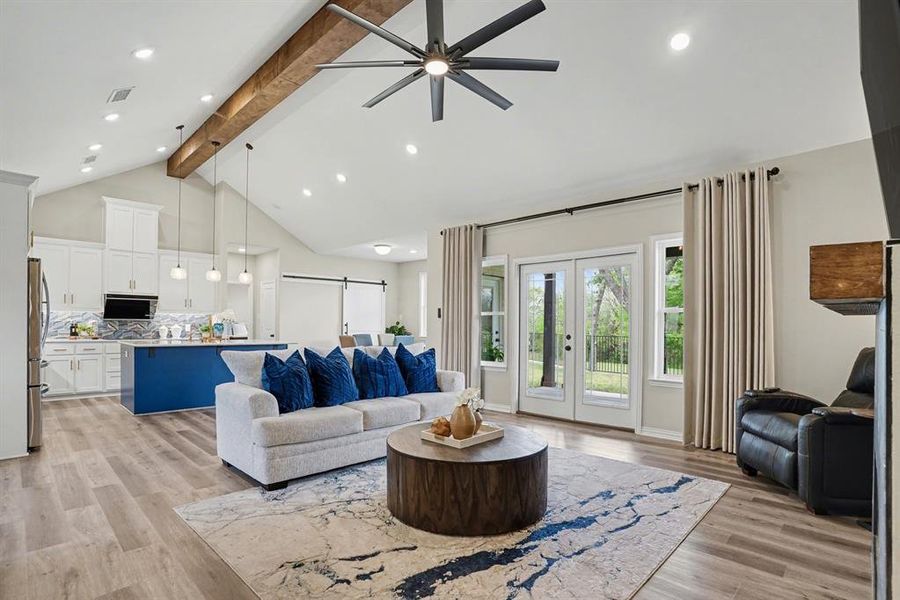 Living area featuring views to back yard, recessed lighting, a barn door, ceiling fan, and light wood finished floors