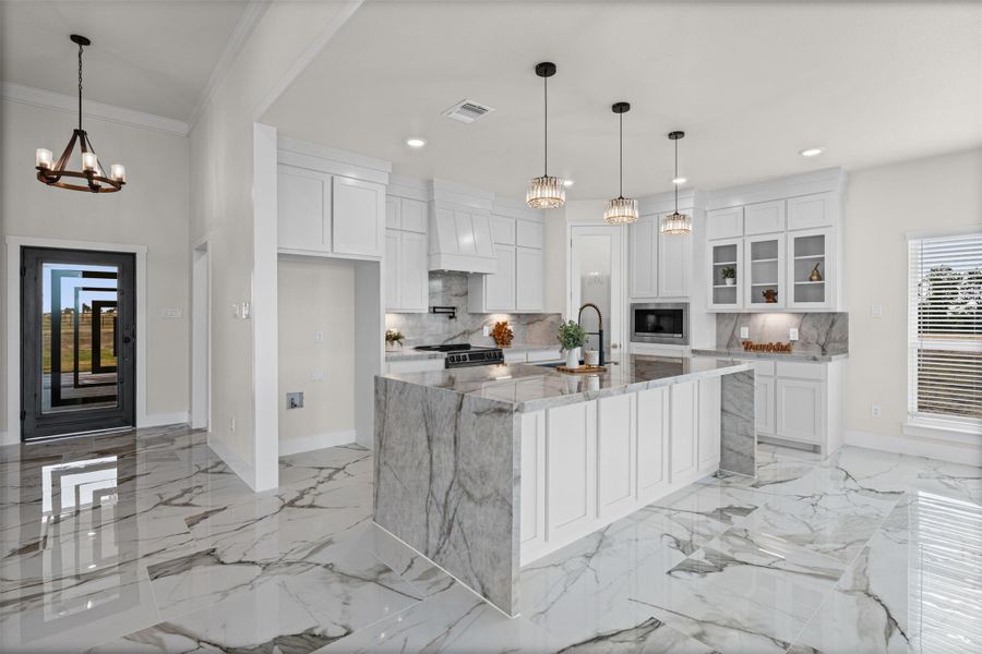 Polished tile flooring and an elegant stone island anchors this open culinary space.