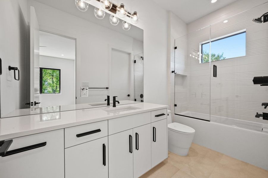 Bathroom with enclosed tub / shower combo, vanity, and recessed lighting
