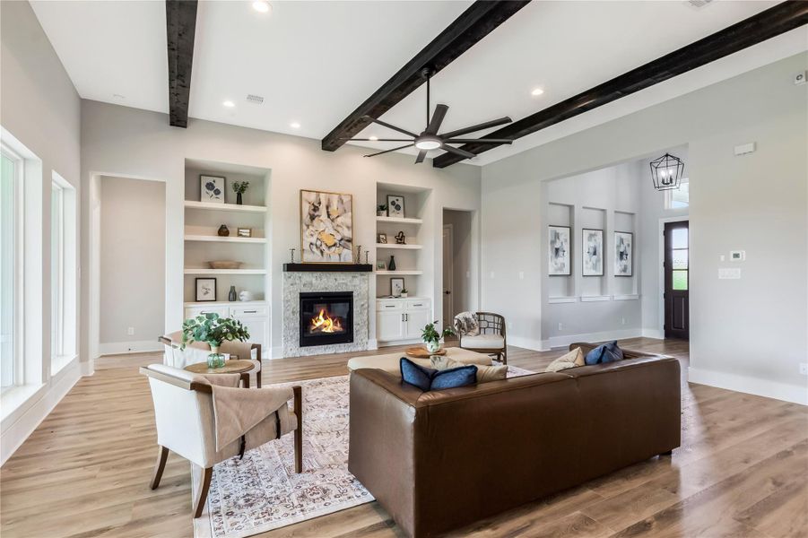 Family room boasts high ceilings with exposed beams and ample natural light from large windows. Family room boasts high ceilings with exposed beams and ample natural light from large windows.