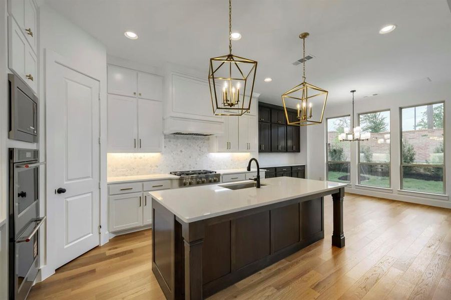 The kitchen features hardwood floors, an island with a light-colored countertop, and a gas range