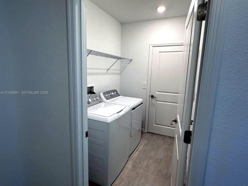 Laundry room featuring tile flooring, a recessed ceiling light, and built-in wire shelving