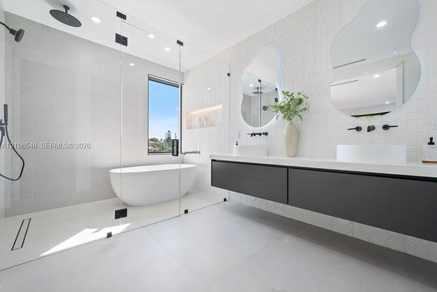 Modern bathroom featuring a glass-enclosed wet room with a freestanding soaking tub, floating double-drawer vanity, dual vessel sinks, and matte black wall-mounted fixtures