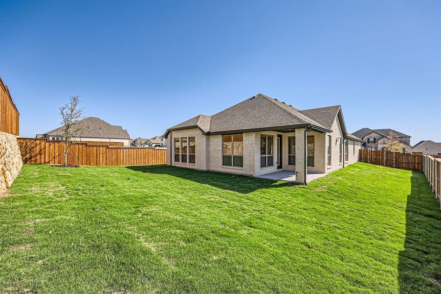 Back of property with a patio and a lawn