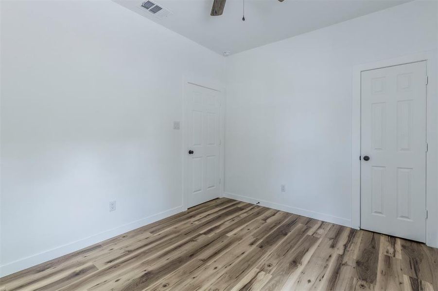 Empty room with light wood-type flooring, baseboards, and a ceiling fan Empty room with light wood-type flooring, baseboards, and a ceiling fan
