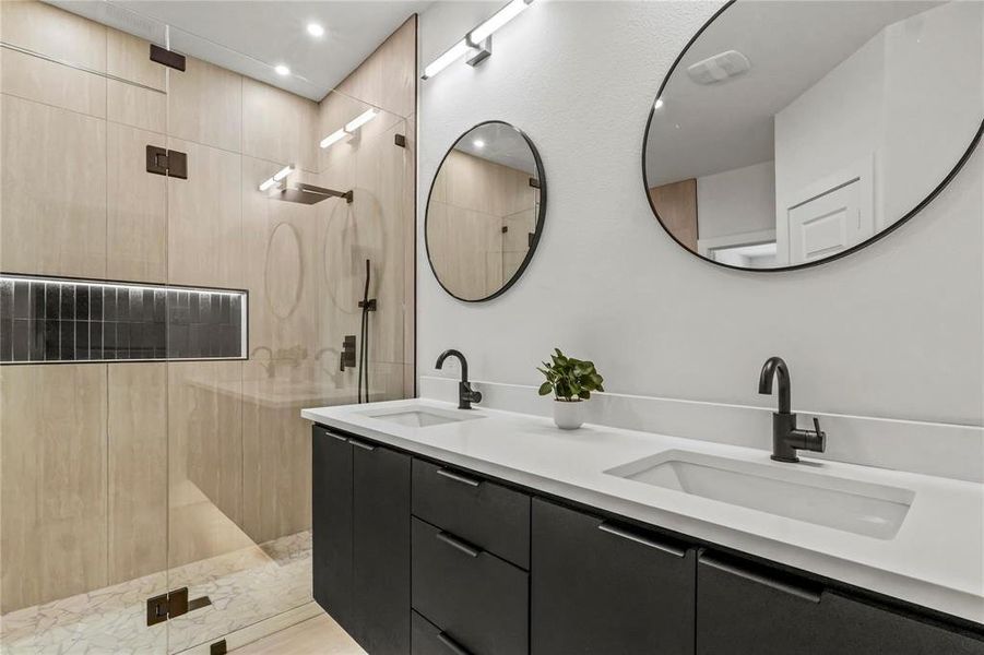 Bathroom featuring a walk in shower, double vanity, and recessed lighting Bathroom featuring a walk in shower, double vanity, and recessed lighting