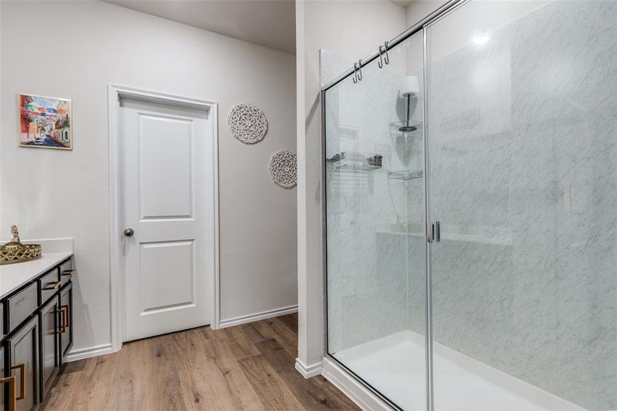 Full bath with vanity, light wood-style floors, and a shower stall Full bath with vanity, light wood-style floors, and a shower stall