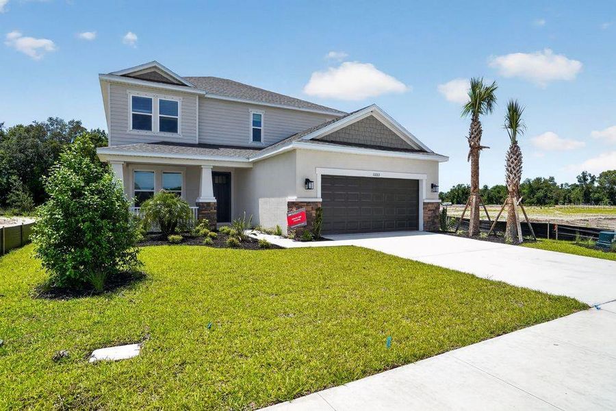 Front exterior of a new home in Firethorn, Parrish, FL, highlighting curb appeal (Image 1). Front exterior of a new home in Firethorn, Parrish, FL, highlighting curb appeal (Image 1).