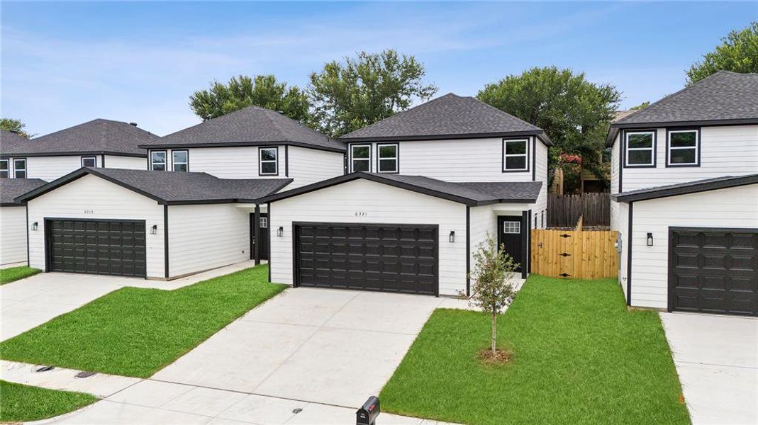 View of front of property featuring a garage and a front lawn