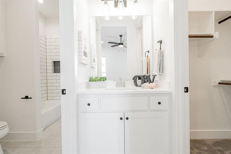 Bathroom featuring ceiling fan, vanity, toilet, and tile patterned floors