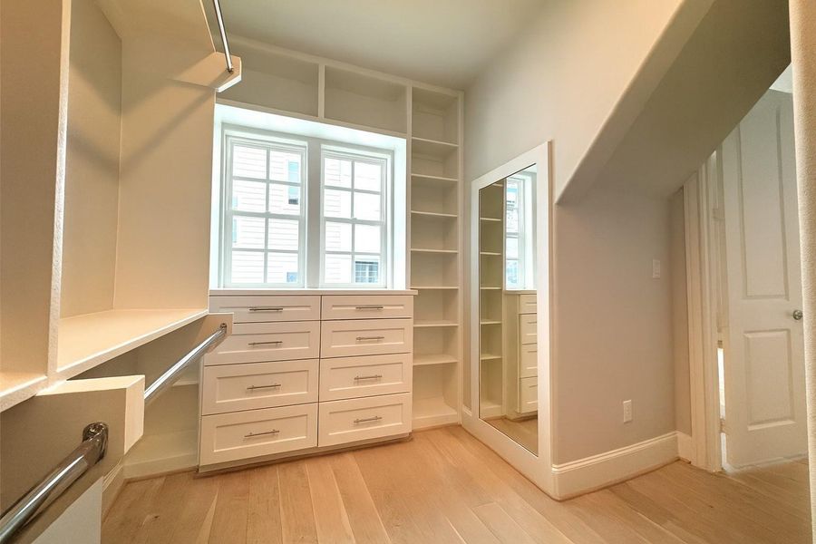 Primary closet (1 of 2) features custom built-ins.