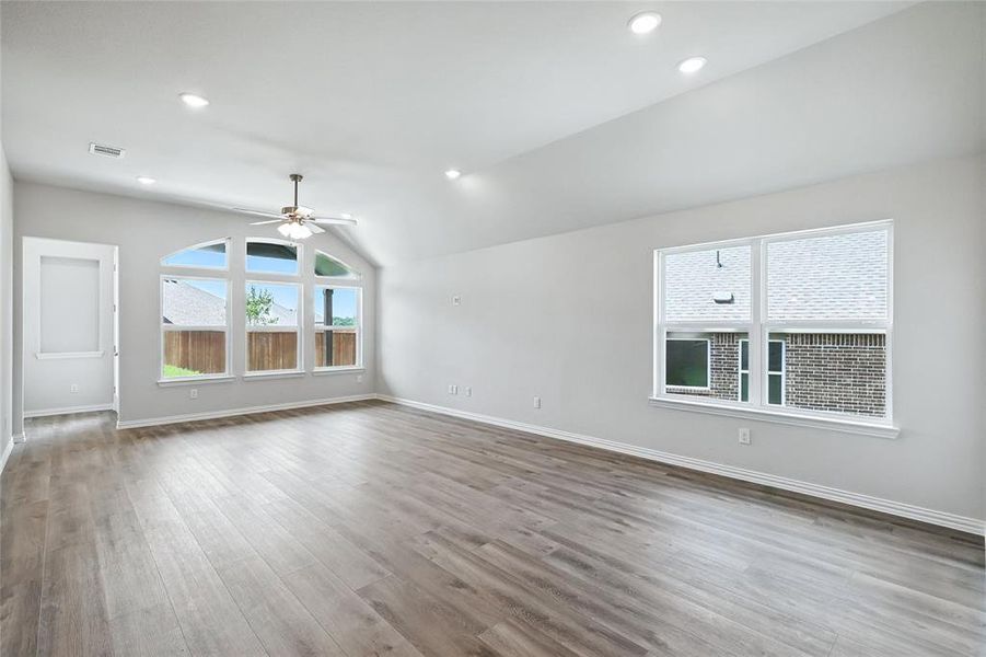 Unfurnished room featuring vaulted ceiling, light wood-style floors, ceiling fan, and recessed lighting