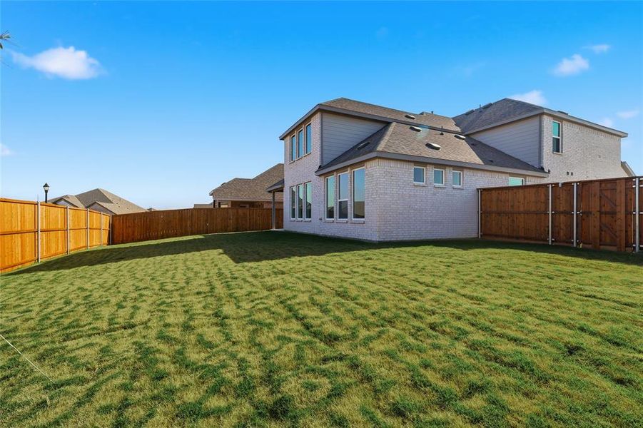 Back of property with brick siding, a fenced backyard, and roof with shingles Back of property with brick siding, a fenced backyard, and roof with shingles