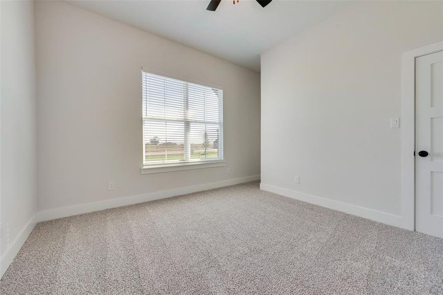 Carpeted spare room with ceiling fan