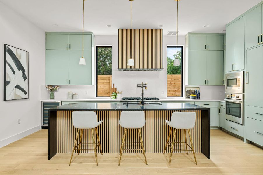 A contemporary kitchen features a sleek island with breakfast bar seating and built-in appliances, complementing stylish cabinetry. A contemporary kitchen features a sleek island with breakfast bar seating and built-in appliances, complementing stylish cabinetry.