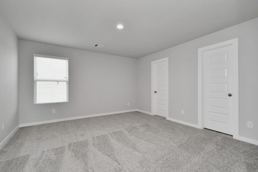 Secondary bedroom. Plush carpet, neutral paint color, large windows, and spacious closets. Sample photo of completed home with similar floor plan. Actual colors and selections may vary.