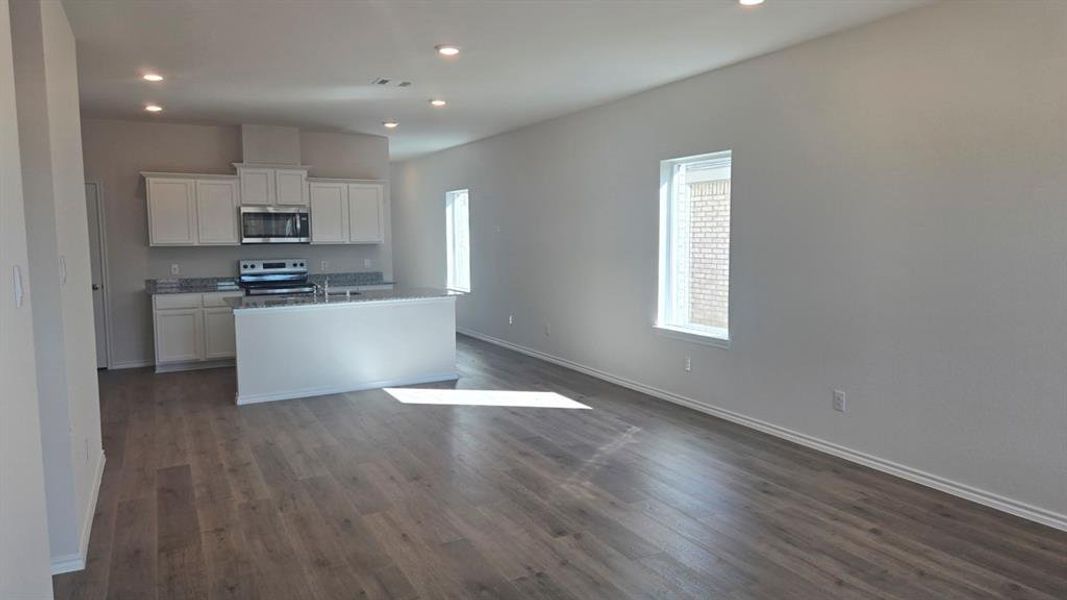 Kitchen with white cabinetry, recessed lighting, a kitchen island with sink, stainless steel appliances, and open floor plan