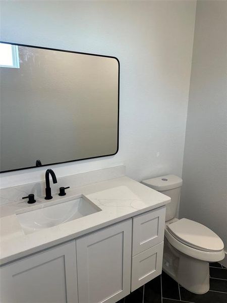 Bathroom with tile patterned floors, vanity, and toilet