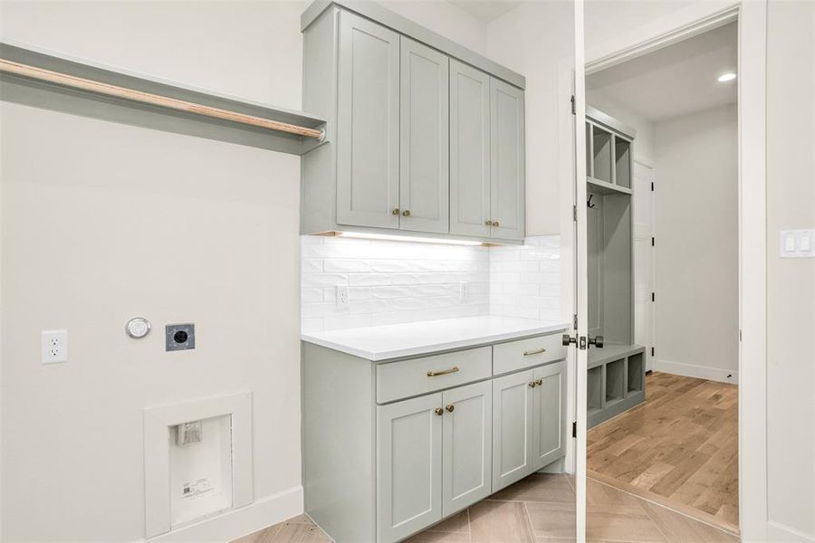 Laundry room with electric dryer hookup, parquet floors, cabinet space, and recessed lighting Laundry room with electric dryer hookup, parquet floors, cabinet space, and recessed lighting
