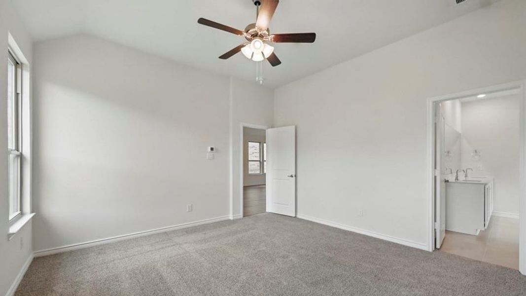 Spacious room with vaulted ceiling and grey carpet flooring