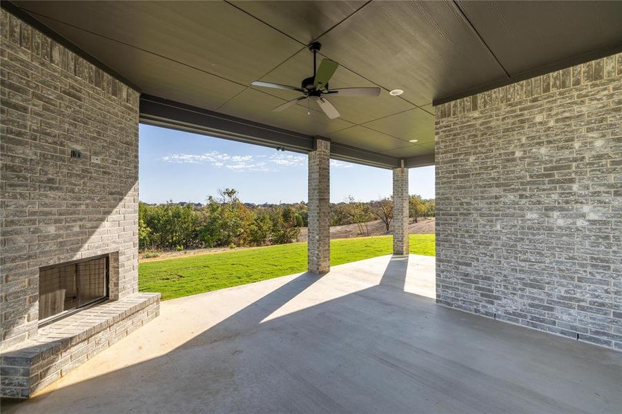 View of patio / terrace with ceiling fan and an outdoor brick fireplace