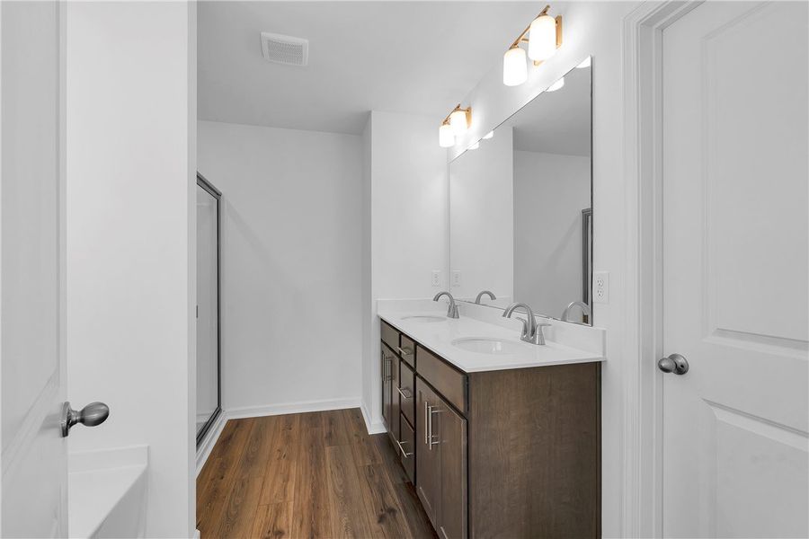 Modern bathroom featuring dual sinks, a spacious v