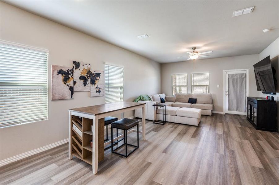 Living room with ceiling fan and light wood-style flooring
