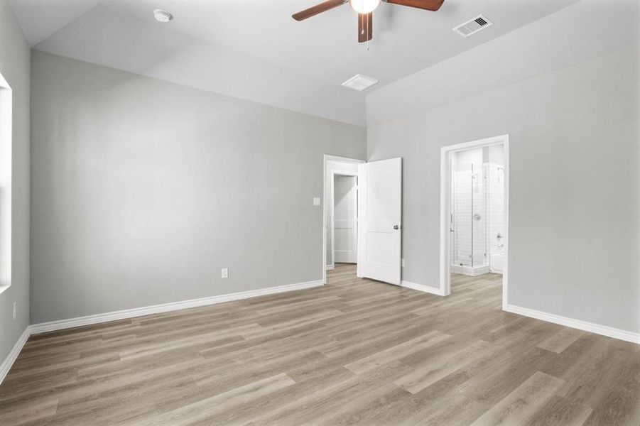 Primary bedroom with a view of the bathroom and hallway.  Plenty of room to host all of your furniture.