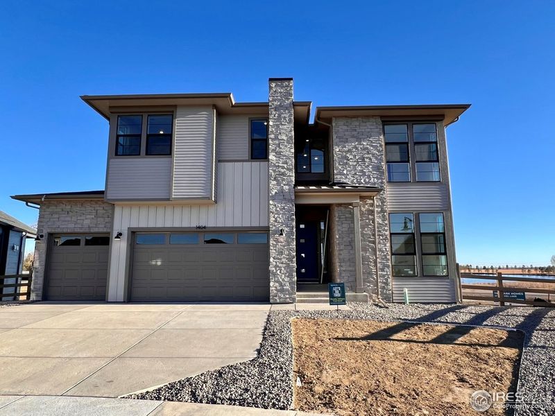 Front exterior of a new home in Kitchel Lake at Serratoga Falls, Timnath, CO, highlighting curb appeal (Image 2). Front exterior of a new home in Kitchel Lake at Serratoga Falls, Timnath, CO, highlighting curb appeal (Image 2).