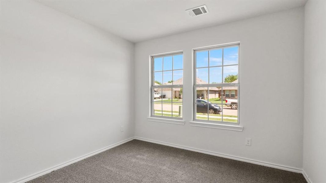 Spacious room featuring neutral paint, gray carpet flooring, dual windows with grid patterns, and white trim