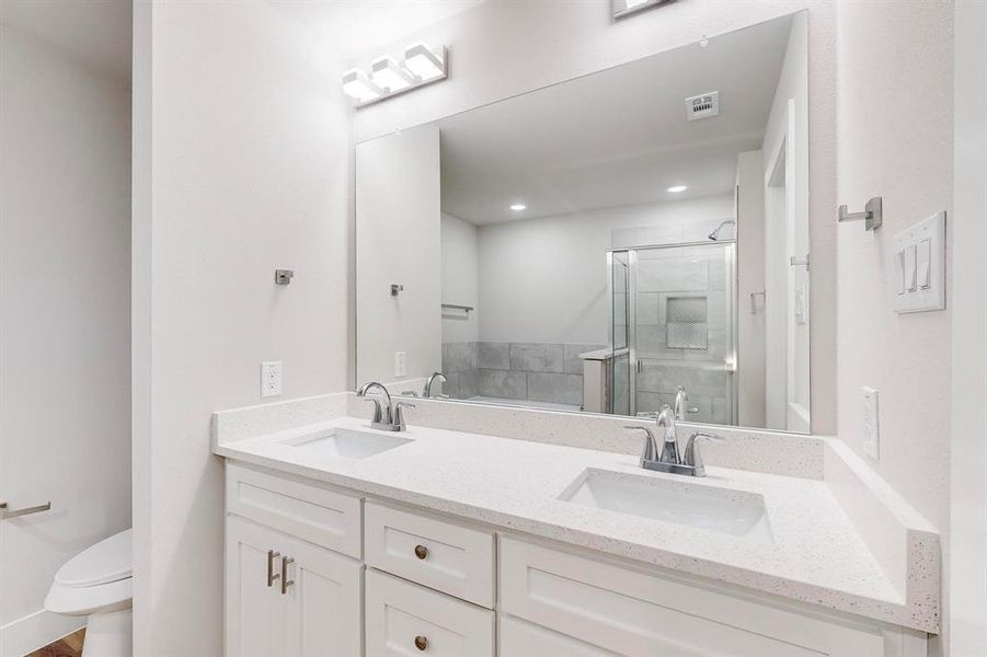 Bathroom with vanity, toilet, and a shower with door