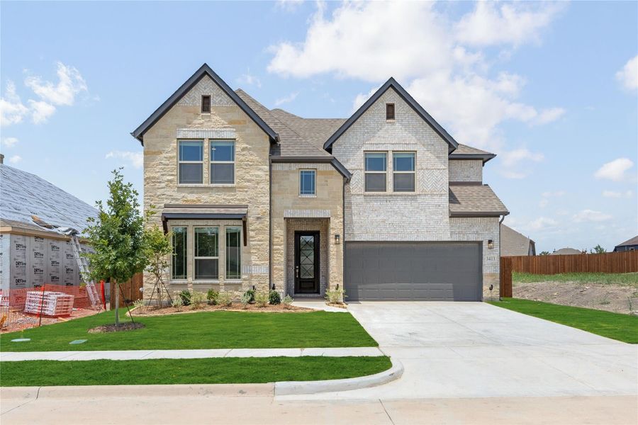 Two-story new construction home with stone and brick exterior, two-car garage, and green front lawn Two-story new construction home with stone and brick exterior, two-car garage, and green front lawn