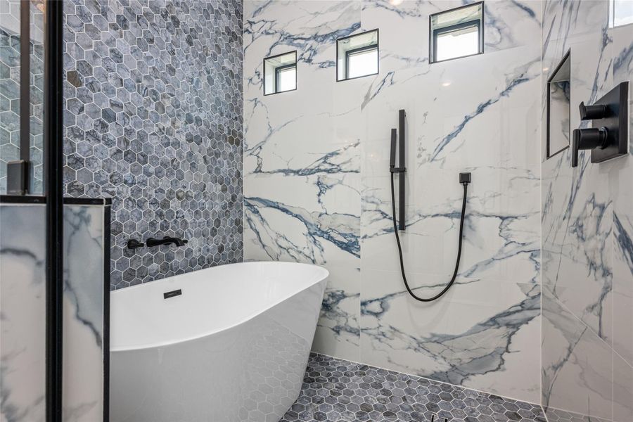 Step into a true spa shower experience—porcelain-tiled to the ceiling with three shower heads: rainfall, handheld, and wall-mounted—all inside the standalone tub enclosure Step into a true spa shower experience—porcelain-tiled to the ceiling with three shower heads: rainfall, handheld, and wall-mounted—all inside the standalone tub enclosure