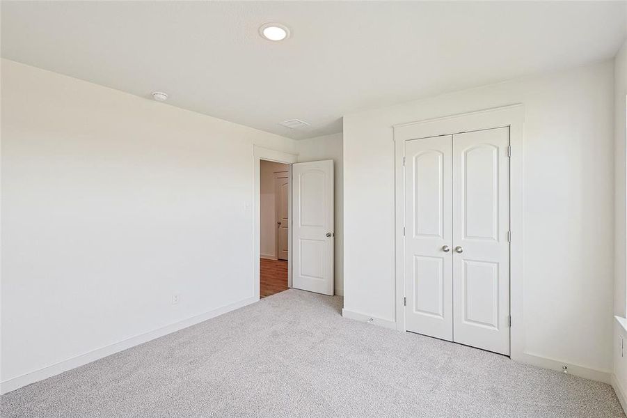 Unfurnished bedroom featuring light colored carpet and a closet