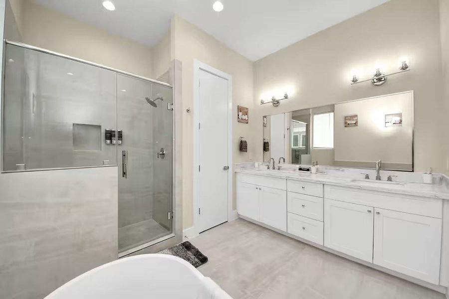 Start and end the day with room to spread out. The primary bath offers an extended vanity, generous storage, and a freestanding soaking tub.