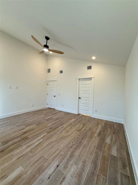 Empty room featuring wood finish floors, lofted ceiling, and ceiling fan