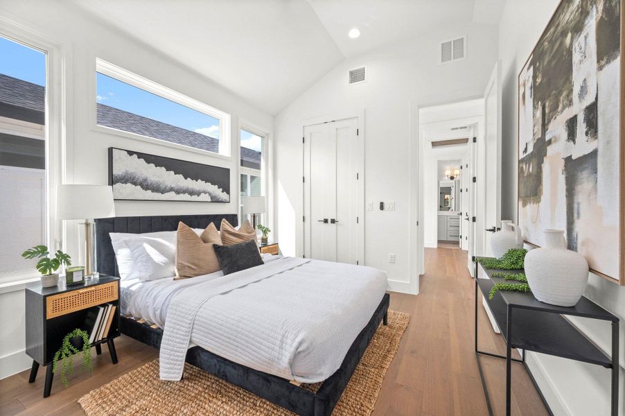Bedroom with wood finished floors, lofted ceiling, a closet, and recessed lighting Bedroom with wood finished floors, lofted ceiling, a closet, and recessed lighting