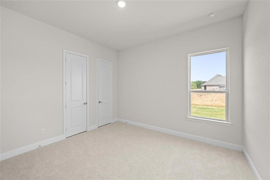 Unfurnished bedroom with light carpet