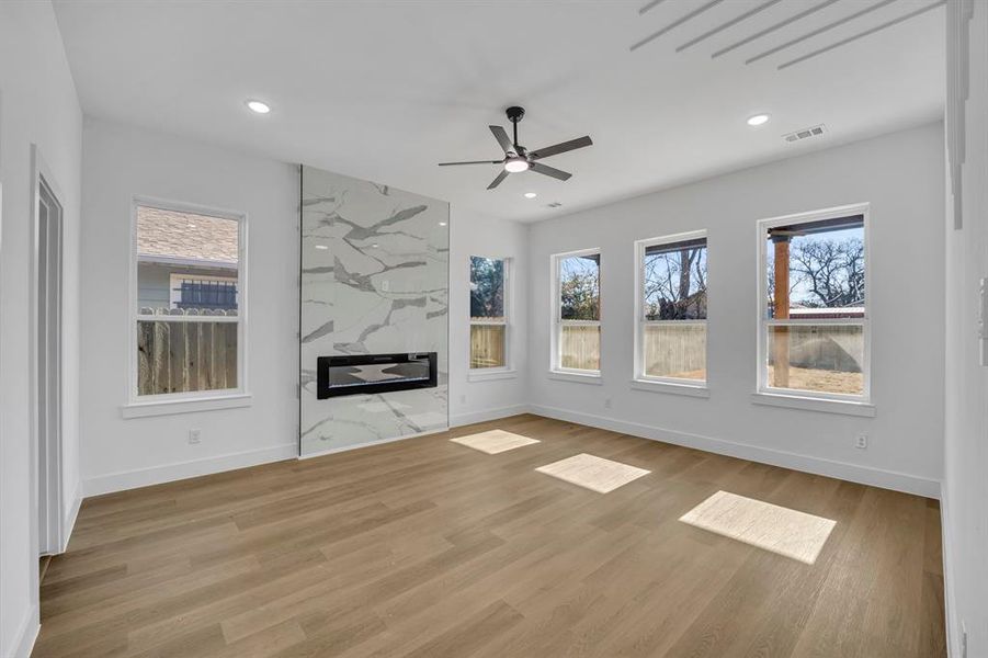 Unfurnished living room with ceiling fan and light wood-type flooring