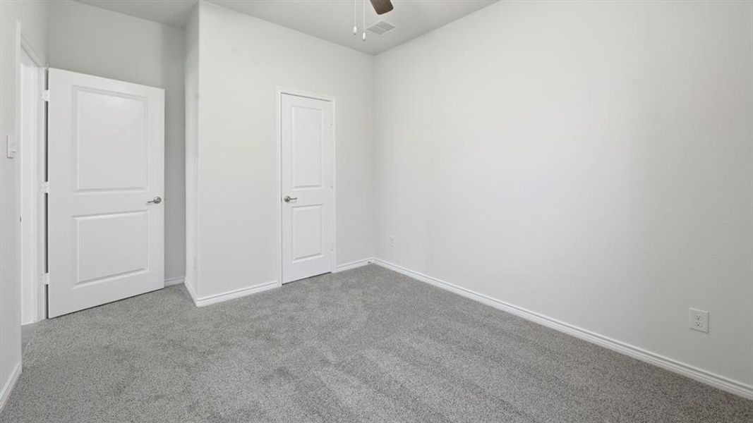 Unfurnished bedroom featuring carpet flooring and a ceiling fan Unfurnished bedroom featuring carpet flooring and a ceiling fan