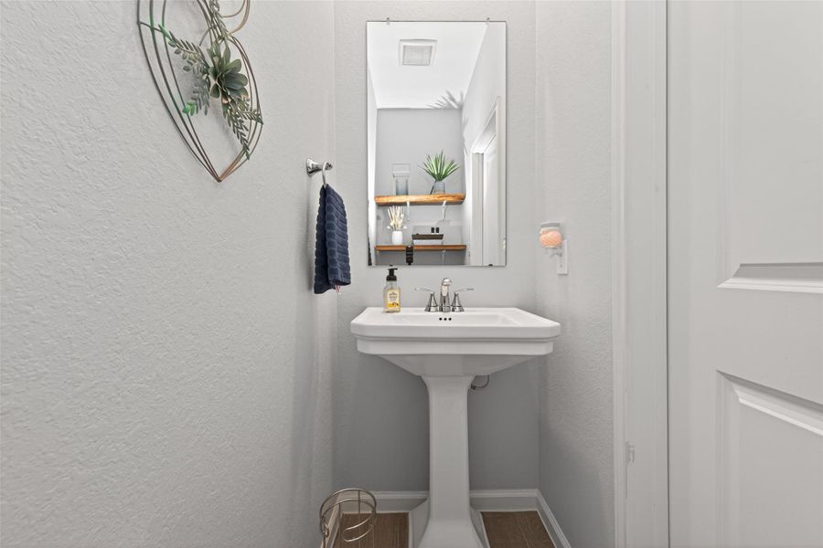 Powder room featuring a pedestal sink and functional layout