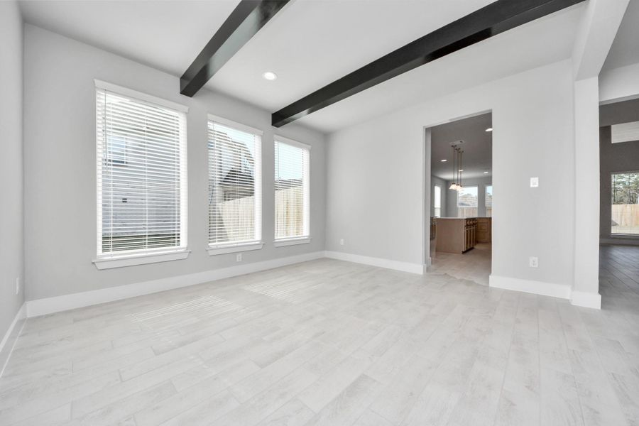 Create lasting memories with your family and friends at the dining table! This expansive dining room showcases sophisticated flooring, custom paint, and seamlessly connects to the family room and kitchen, providing an open and inviting atmosphere.