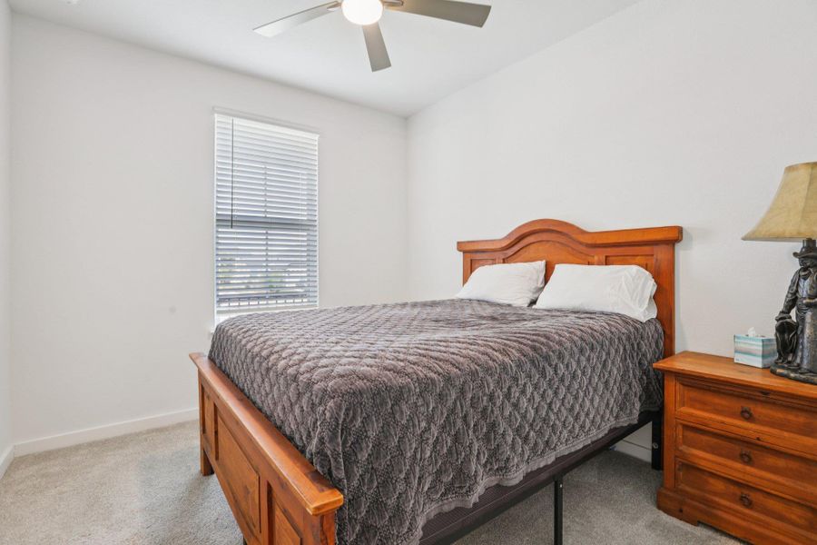 Bedroom featuring light carpet and a ceiling fan Bedroom featuring light carpet and a ceiling fan