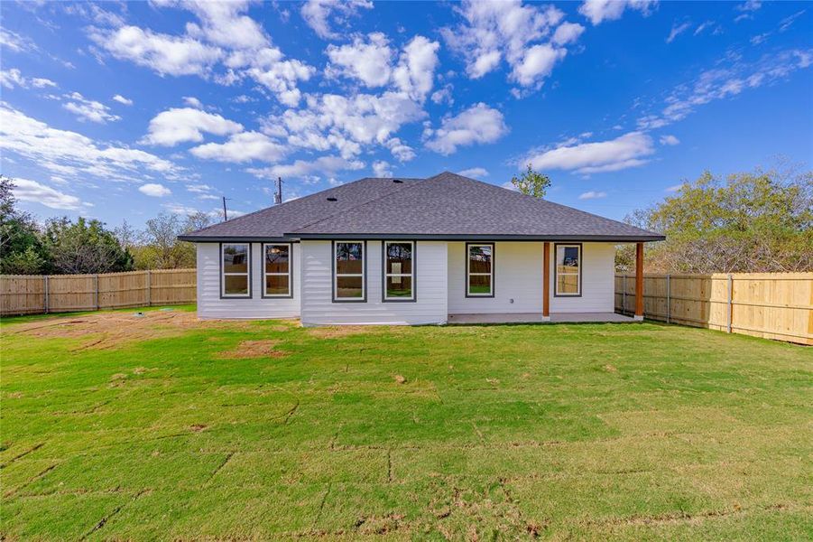 Back of property featuring a lawn