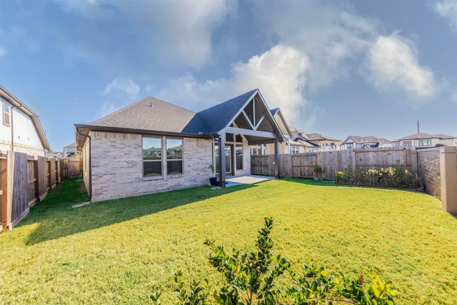 The large, fully fenced backyard offers plenty of room for play, pets, or future outdoor enhancements. With the home’s striking gabled patio and expansive windows as a backdrop, this space is ideal for entertaining or unwinding in privacy. The large, fully fenced backyard offers plenty of room for play, pets, or future outdoor enhancements. With the home’s striking gabled patio and expansive windows as a backdrop, this space is ideal for entertaining or unwinding in privacy.